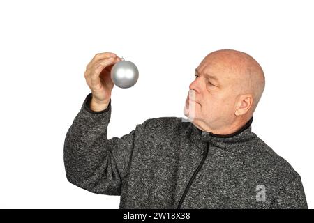 Mature Caucasian Man Holding Silver Christmas Tree Ornament in Grey Sweater Jacket - Festive Seasonal Portrait with Copy Space Stock Photo