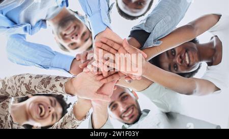 Closeup portrait, bottom view, happy faces of different team employees standing in circle Stock Photo
