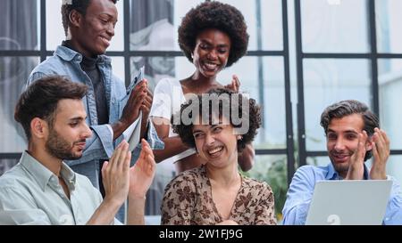 Employees working at computer together, discussing content Stock Photo