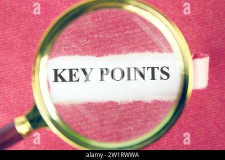 KEY POINTS the text, the word can be seen through a magnifying glass on torn paper Stock Photo