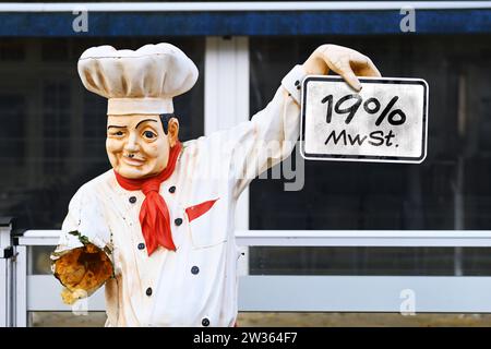 FOTOMONTAGE, Derangierte Figur eines Kochs vor einem Restaurant mit Schild und Aufschrift 19% MwSt., in der Gastronomie wird die Umsatzsteuer auf Spei Stock Photo