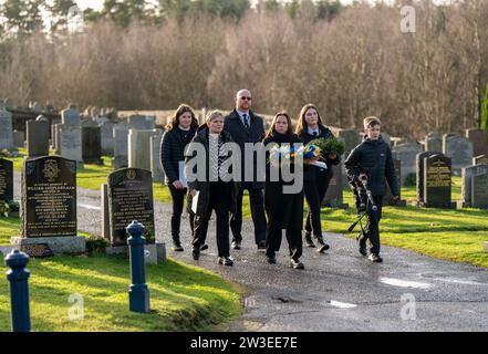 People gather to pay their respects at a wreath laying ceremony to mark the 35th anniversary of the Lockerbie bombing at the Memorial Garden, Dryfesdale Cemetery, Lockerbie. On December 21, 1988, Pan Am Flight 103 exploded over the town in Dumfries and Galloway, 40 minutes into its flight from London to New York. All 259 passengers and crew were killed, including 35 students from the University of Syracuse, along with 11 Lockerbie residents. Picture date: Thursday December 21, 2023. Stock Photo