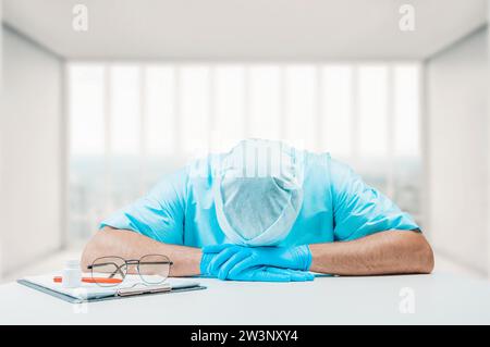 The doctor in the clinic fell asleep at the workplace. Medicine concept. Mixed media Stock Photo