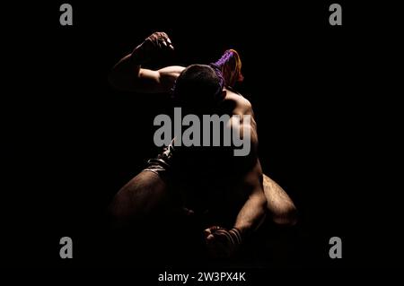 Thai boxer punches on the floor of the ring. Mongkhon. The concept of tournaments, Thai boxing and kickboxing. Mixed media Stock Photo