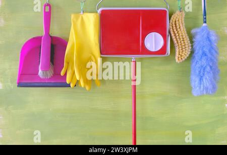 Spring cleaning composition with cleaning supplies, tools hanging on green background, negative space, free copy space Stock Photo