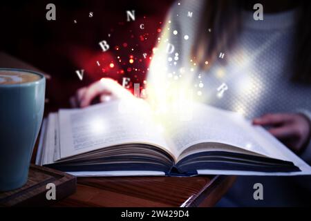Woman reading shiny magic book with letters flying over it, closeup Stock Photo