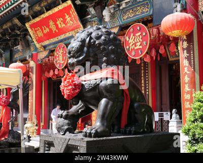 November 13, 2023. Wong Tai Sin Temple - Wong Tai Sin area, Hong Kong. Black color statue of lion dog in front of Wong Tai Sin temple's main building. Stock Photo