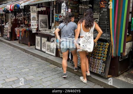 Two young female tourists looking at the goods in a stall, Old Town Josefov Jewish Quarter Prague Czech Republic Europe U starého hřbitova Street Stock Photo