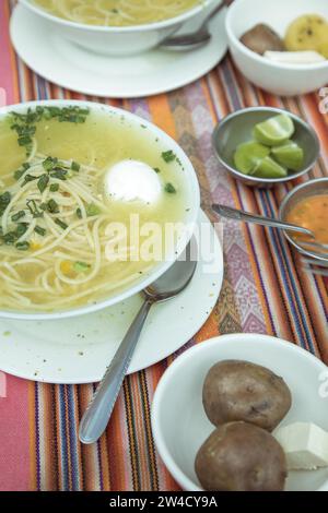 Sopa de gallina with egg, chicken soup, traditional dish in the Andean highlands of Peru, with lime, boiled potatoes, fresh cheese and aji, La Stock Photo