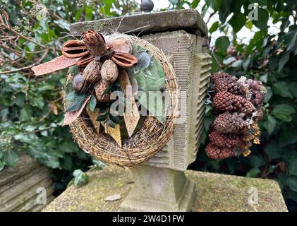 Wreath and pine cones on a tombstone in the public cemetery Stock Photo