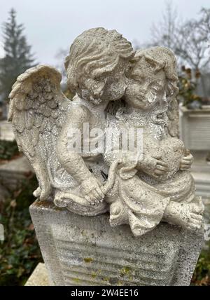 Two angel figurine on a tombstone in the public cemetery Stock Photo
