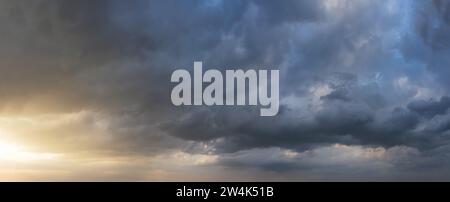 Dramatic sunset sky with dark rainy clouds. Nature background. Sky panorama. Stock Photo