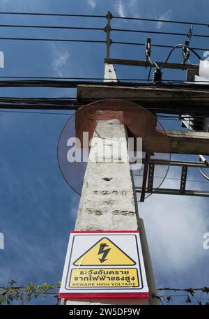 beware high voltage sign, written in thai and english, with warning symbol, in phetchabun, thailand Stock Photo