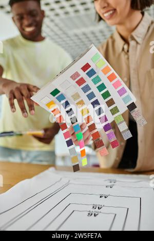 blurred interracial fashion designers holding color palette while working in print studio, teamwork Stock Photo