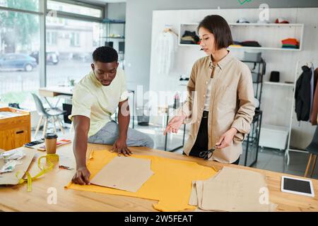 young multicultural clothes designers working with sewing patterns in professional print studio Stock Photo