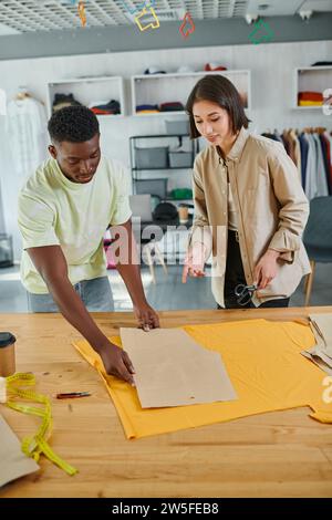 creative multicultural clothes designers working with sewing patterns in modern  print studio Stock Photo