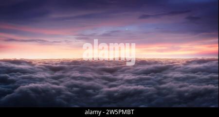 Dramatic sunrise sky above fluffy clouds early in the morning from aerial drone view. Stock Photo