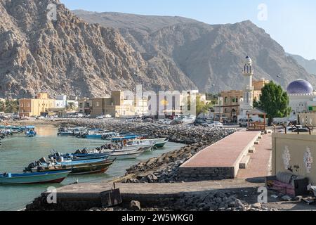 Boats moored at the end of the eastern Sea Canal with Khasab town behind, Musandam, Oman Stock Photo