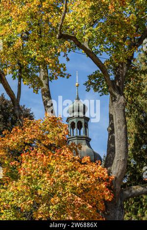 Svojsin, Czech Republic - October 13 2023: View of the cupola of the Saint Petr and Pavel church surrounded by branches with yellow, orange and green Stock Photo
