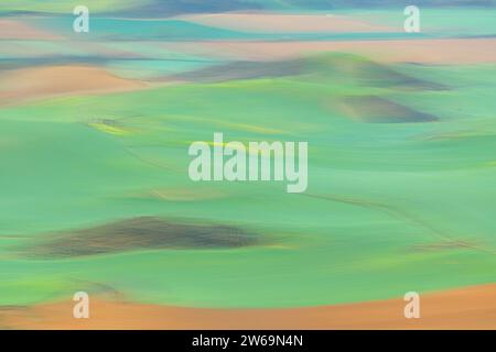 Soft abstract landscape of rolling hills with delicate green and beige hues, evoking a serene pastoral scene Stock Photo