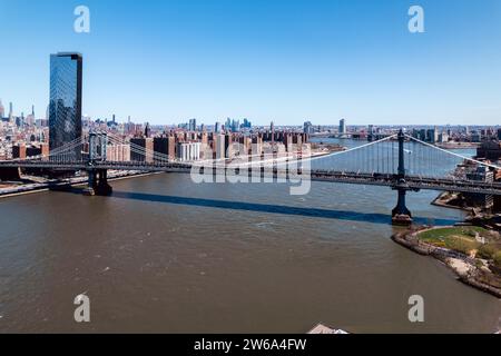 Aerial view of the Manhattan Bridge spanning the East River with the New York City skyline in the backdrop on a clear day. Stock Photo