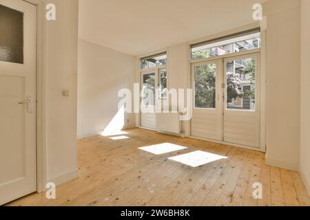 Sunlight falling through window on stained hardwood floor in empty unfinished room at modern home Stock Photo