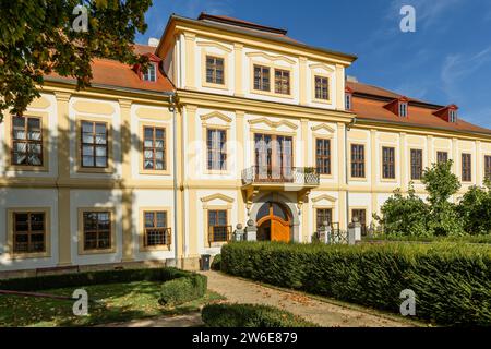 Svojsin, Czech Republic - October 13 2023: Front view of the newly renovated castle, a yellow building with red roof and the park with green bushes Stock Photo