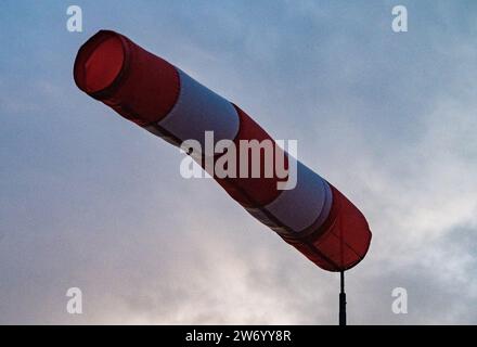 21 December 2023, Mecklenburg-Western Pomerania, Altefähr: A windsock stands in the air at the Rügen Bridge in Altefähr on the island of Rügen at sunset, indicating quite strong winds. The German Weather Service (DWD) had issued a storm warning for the Baltic coast from Rerik to Vorpommern due to the storm depression 'Zoltan'. There was a risk of gale-force winds from Thursday evening at 8 p.m. until Friday lunchtime. (to dpa 'Storm depression 'Zoltan' also disrupts the pre-Christmas period in MV') Photo: Stefan Sauer/dpa Stock Photo