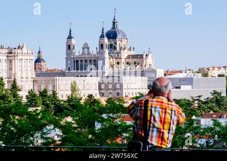 Tourists at the Parque del Oeste Viewpoint, with the Royal Palace, Almudena Cathedral and The Royal Collections Gallery in the background. Madrid, Com Stock Photo