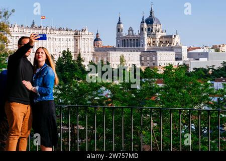 Tourists at the Parque del Oeste Viewpoint, with the Royal Palace, Almudena Cathedral and The Royal Collections Gallery in the background. Madrid, Com Stock Photo