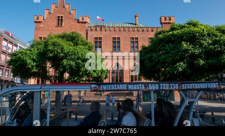 03.09.2018, Poland, Kolobrzeg, West Pomerania - Back of the neo-gothic town hall of Kolberg, in front a city tour with an electric train. 00A180903D02 Stock Photo