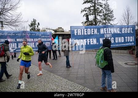 25.11.2023, Germany, Berlin,  - In the run-up to a peace demonstration, a group of peace activists stand with banners at the Soviet memorial in the Ti Stock Photo