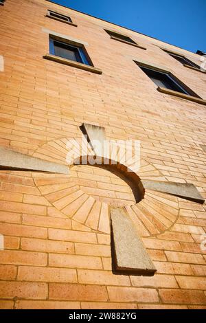Golden brick wall of building with upward view of windows and architecture design and blue sky Stock Photo
