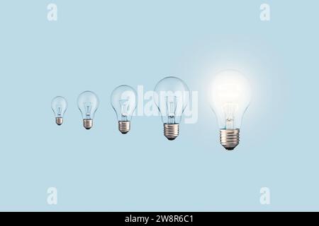 Creative Light Bulbs Loading Process And One Glowing Light Bulb On A Blue Background. Creative Idea, Concept. Uploading A New Idea. Project And Succes Stock Photo