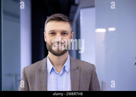 Close-up portrait of mature successful businessman, man smiling and looking at camera inside office building at workplace, satisfied bank investor boss. Stock Photo