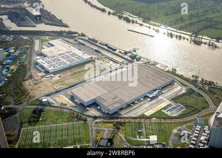 Aerial view, logport VI (Six) industrial area logistics services, inland navigation on the river Rhine with high water, surrounded by autumnal deciduo Stock Photo