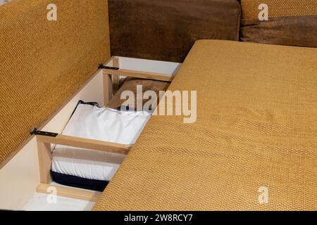 Storage space inside the sofa where the pillows are at home in the apartment, bedroom furniture close-up Stock Photo