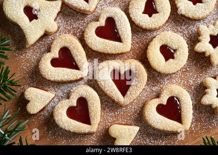 Closeup of homemade Linzer Christmas cookies in the shape of hearts filled with strawberry marmalade Stock Photo