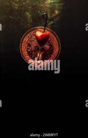 high angle view of pink sparkling wine drink with strawberry heart garnish. copy space. Stock Photo