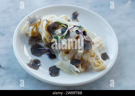 italian food pasta dish tagliatelle truffle sauce in close up on a dining table Stock Photo