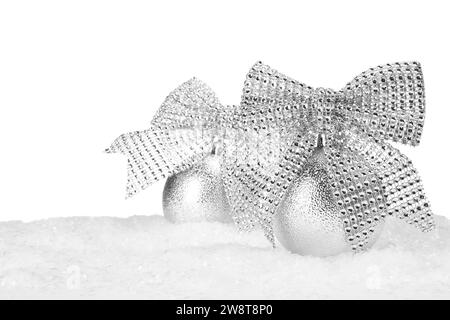 Beautiful silver Christmas balls with bows on snow against white background Stock Photo