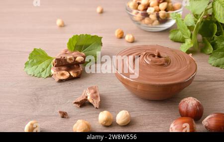 Hazelnut cream with chocolate in glass jar with ingredients on a wooden table. Elevated view. Stock Photo