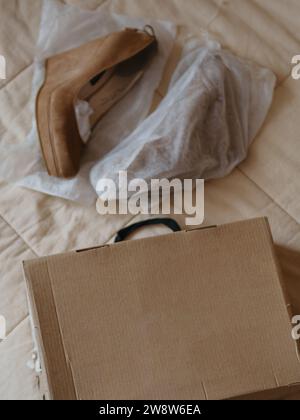 Vertical straight from above close up shot of a shoe box and Women's beige shoes on a solid high platform made of genuine leather (suede). Decorated w Stock Photo