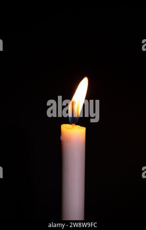 Burning White Candle on the dark, flame of candle on black background Stock Photo