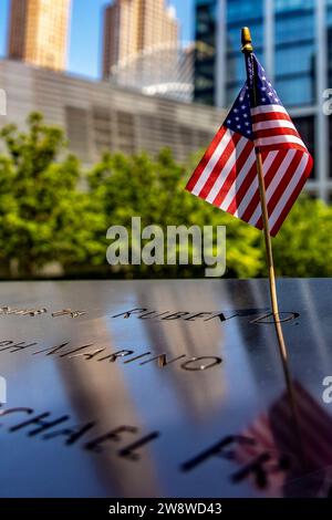 New York, USA; June 1, 2023: Upright photo of an American flag at the World Trade Center memorial, a tribute to the victims of the September 11. Stock Photo