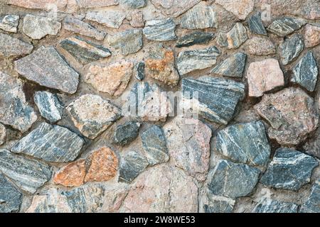 Masonry made of granite stones. Background Stock Photo