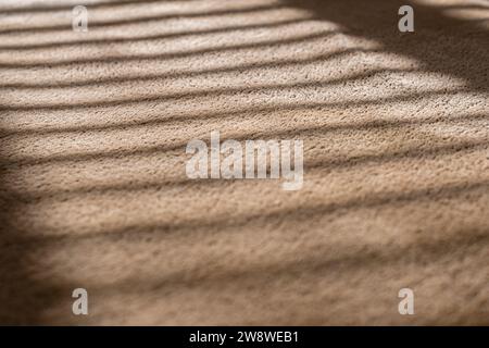 Light brown background from wellsoft fabric, close-up. Velvet texture in sunlight through the blinds Stock Photo