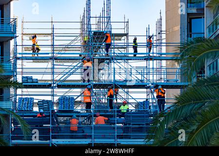 Men in high vis clothing on a complex setup of light weight alloy scaffolding on a multi story site in central Sydney, New South Wales, Australia Stock Photo