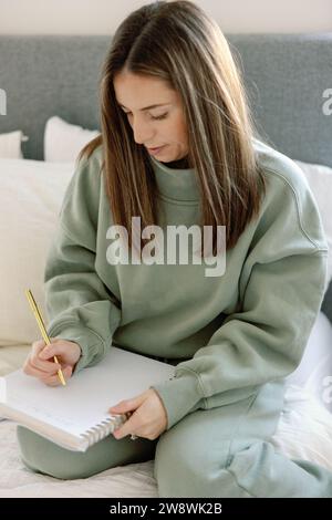 Focused woman listing goals for 2024 Stock Photo