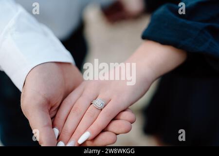 Engaged couple holding hands showing the diamond ring Stock Photo